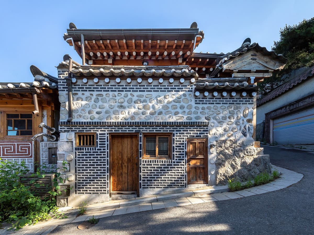 Bukchon Hanok Village — Traditional hanok house with wooden doors along a steeply sloping street in Bukchon Han...