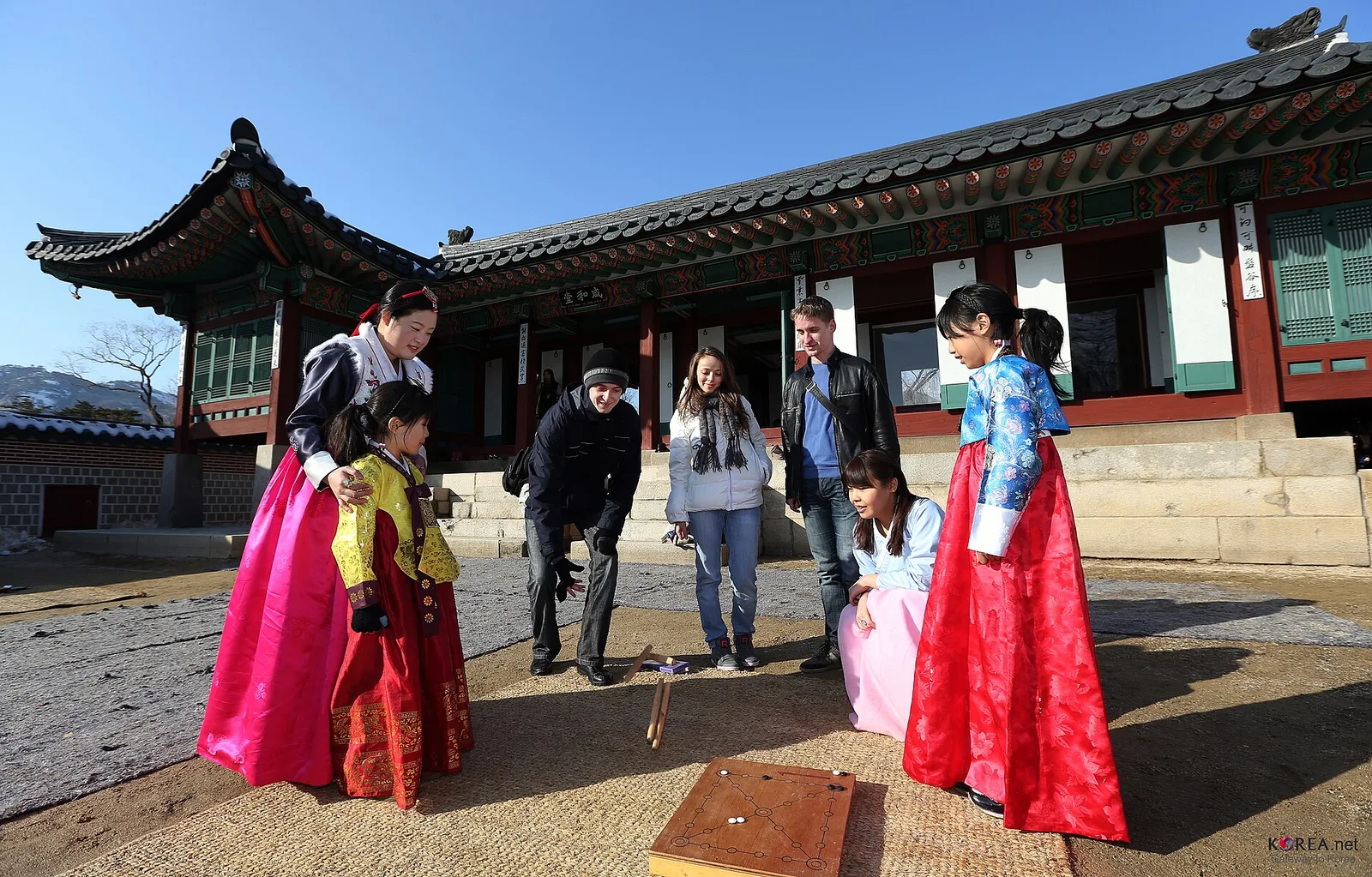 Visitors in hanbok playing a traditional game during a Seollal event in Seoul