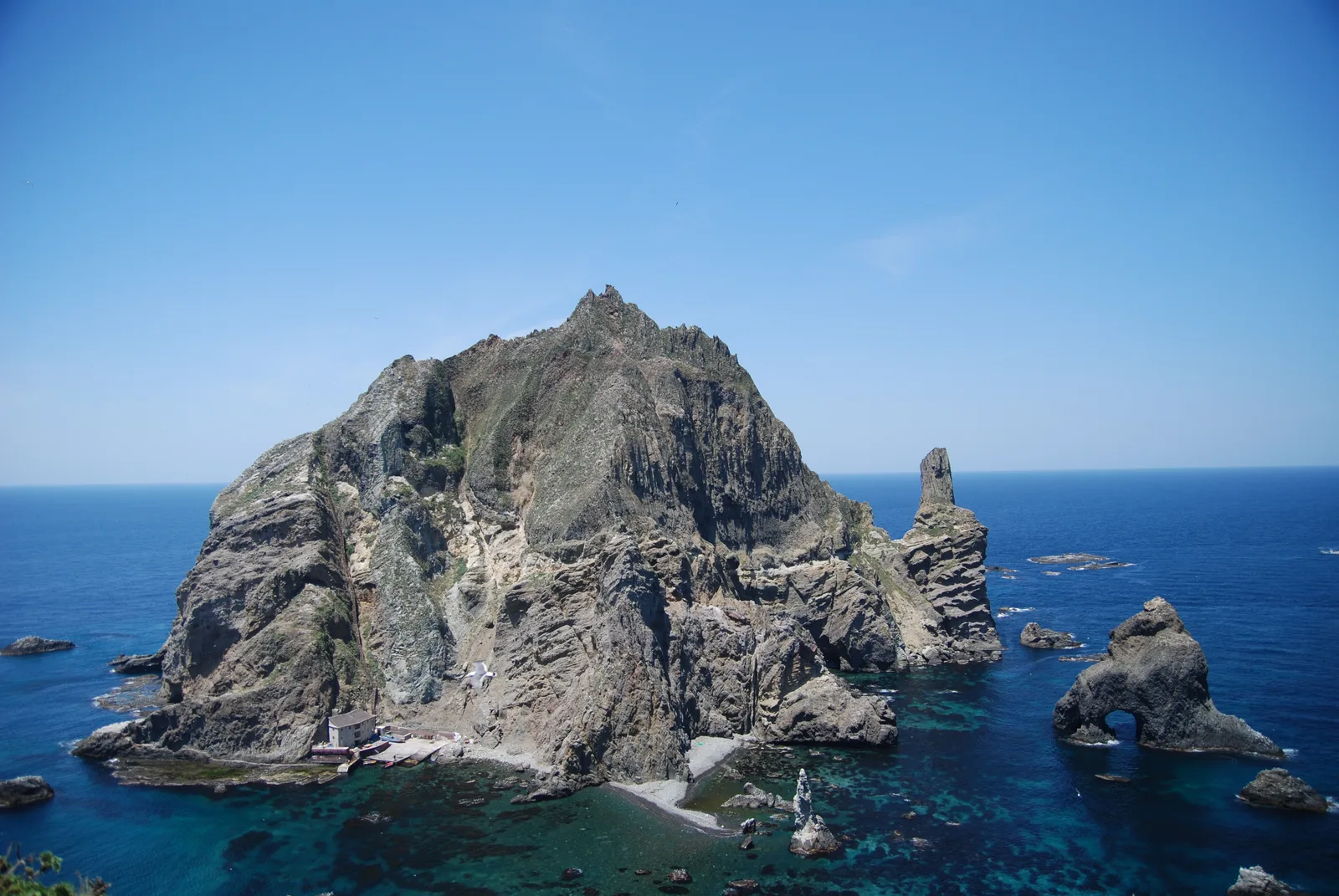 The steep rock face and surrounding sea of Dokdo's West Islet viewed from the East Islet