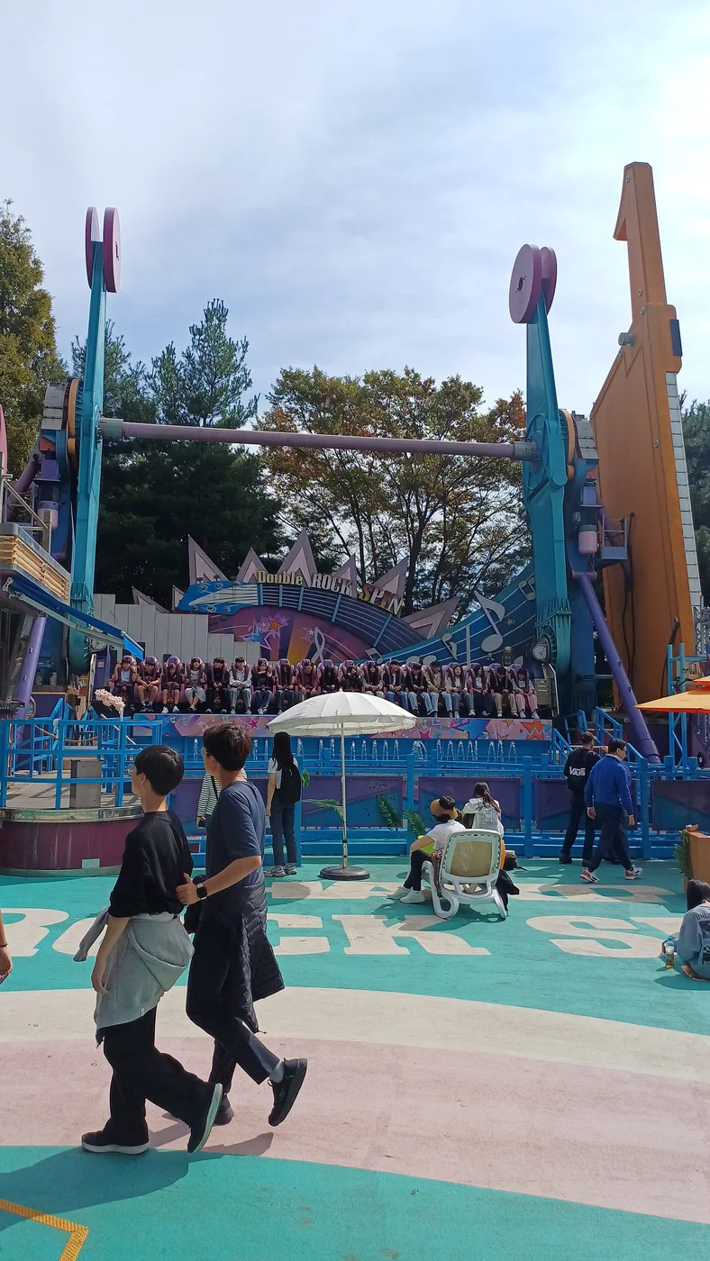 Visitors watching the Double Rock Spin ride operating inside Everland in Yongin