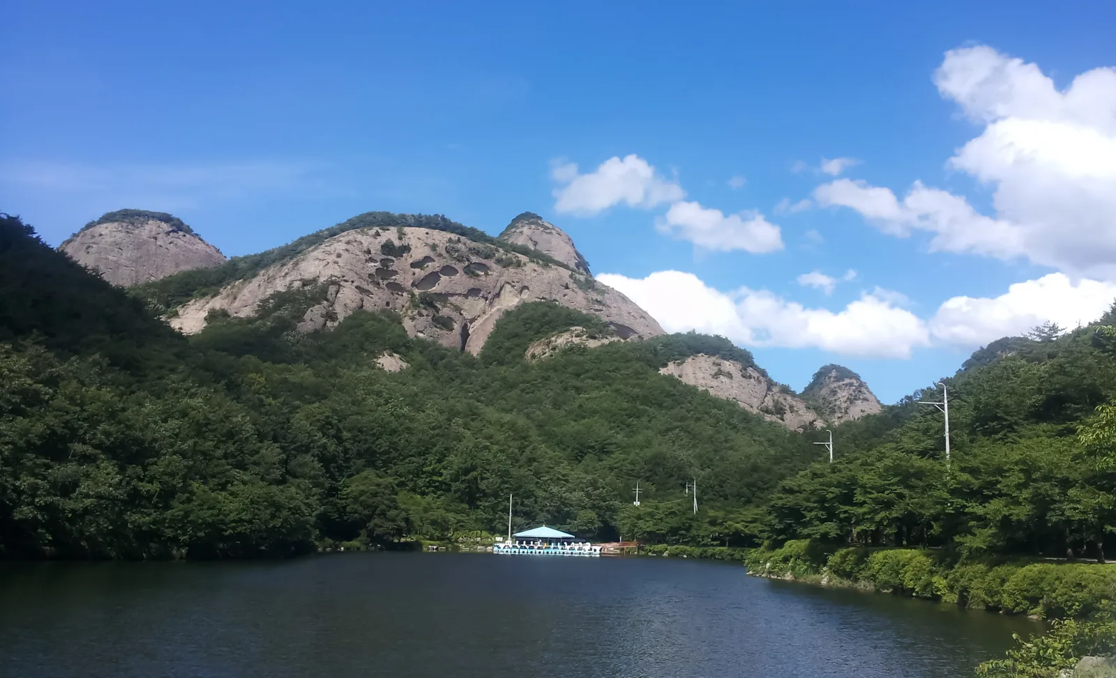 The distinctive twin peaks of Maisan rising above a lake and forest in Jinan