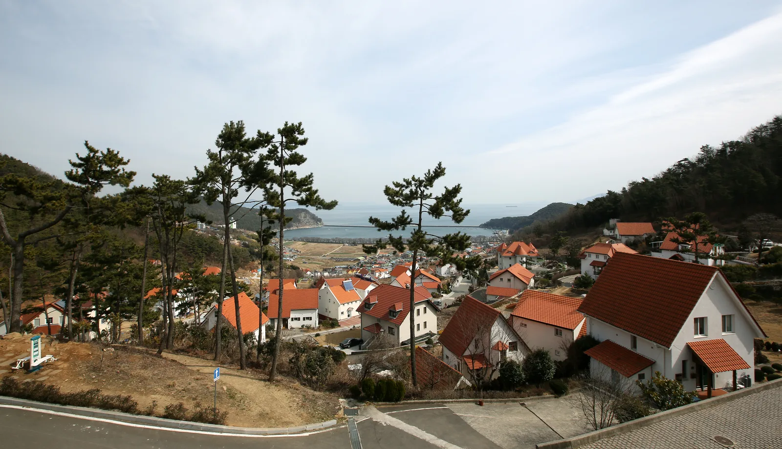 Red-roofed homes of Namhae German Village descending toward the South Sea