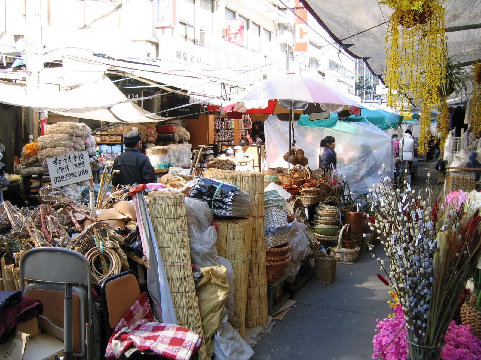 A narrow daytime lane of basket, craft and household-goods stalls inside Daegu Seomun Market