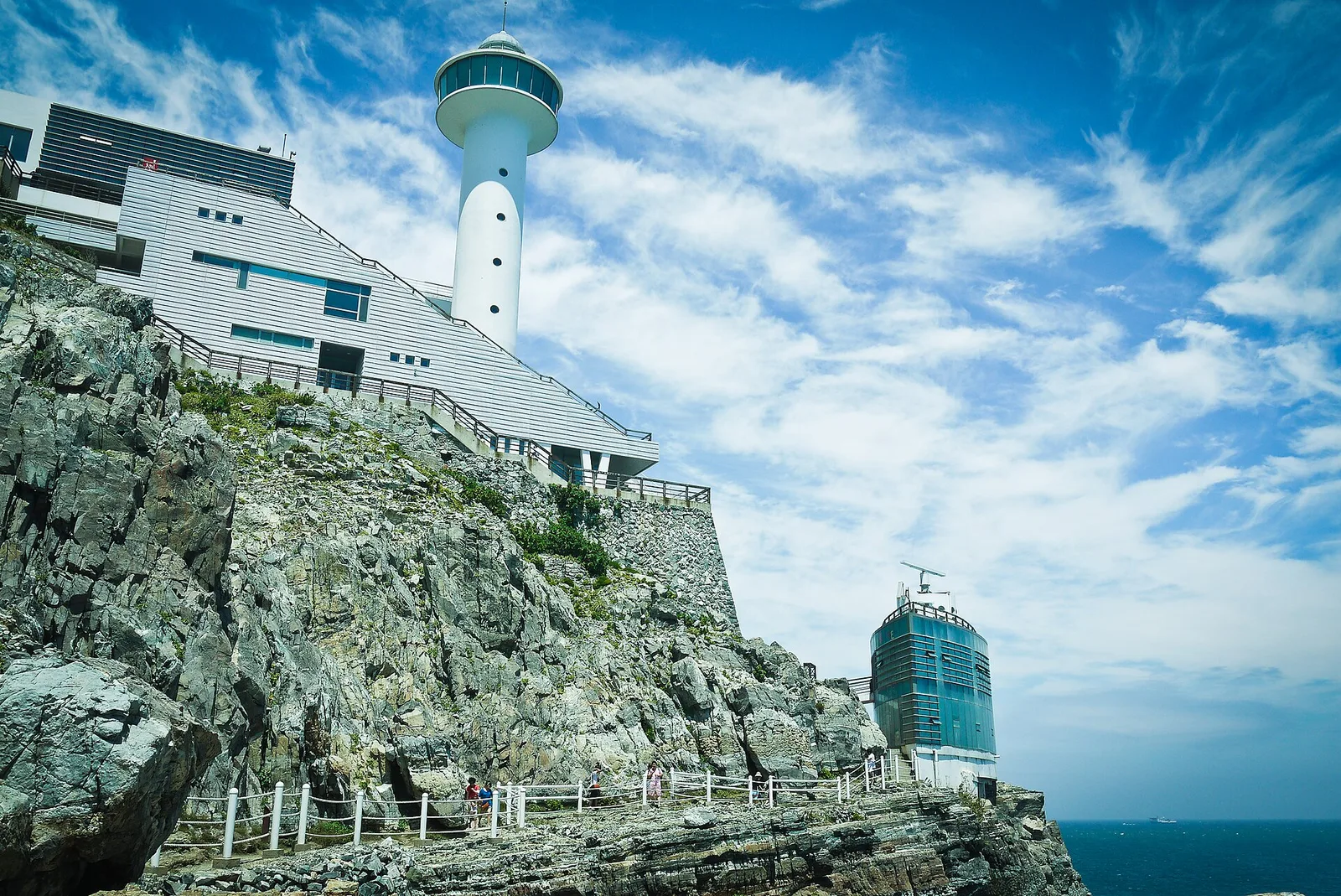 Yeongdo Lighthouse rising above the jagged sea cliffs inside Taejongdae in Busan