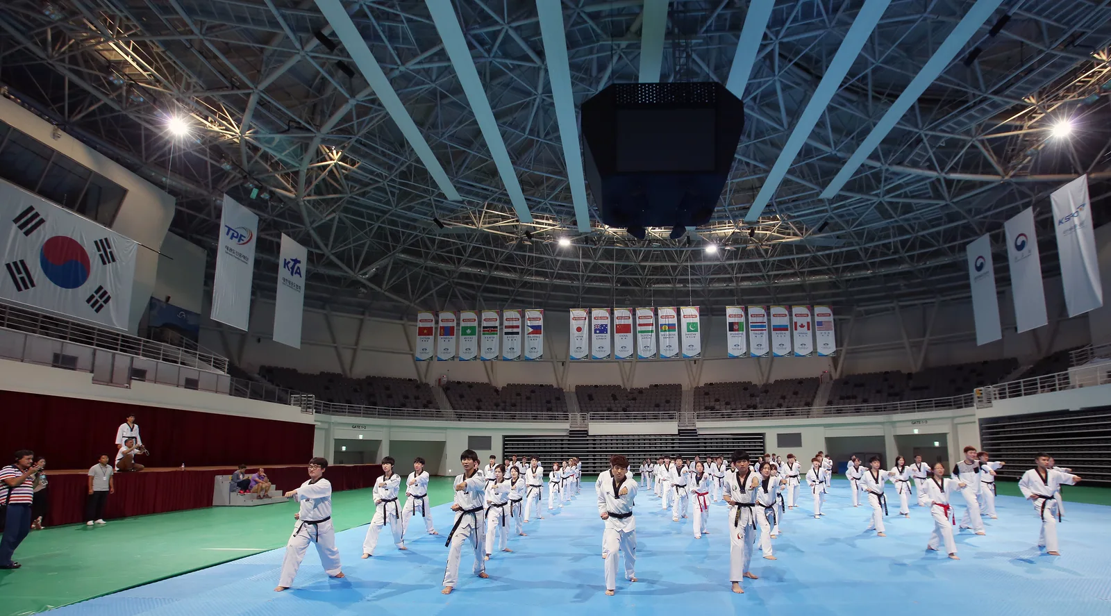 A large taekwondo training session inside the main arena at Taekwondowon in Muju