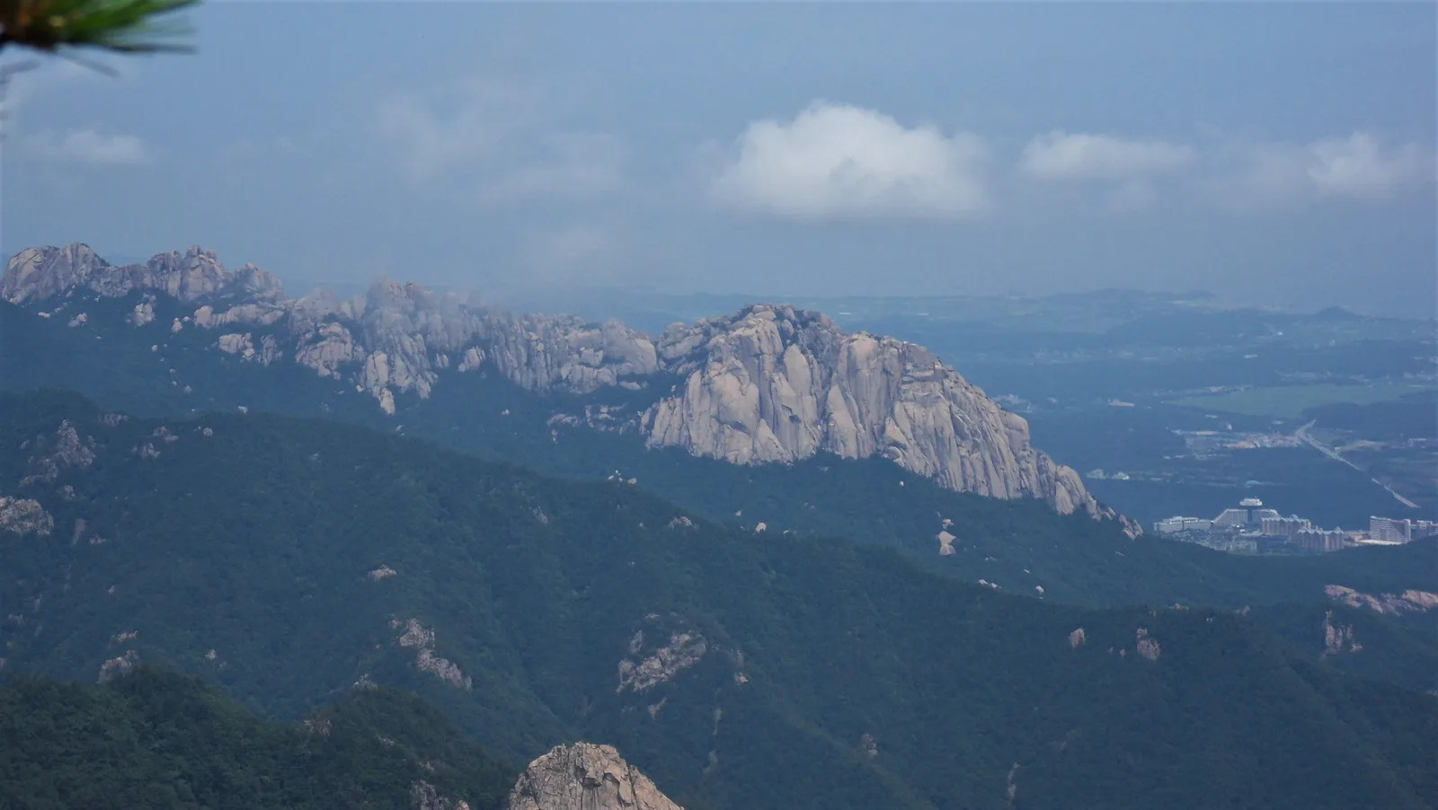 The six-peaked granite wall of Ulsanbawi seen across the forested Seoraksan ridges