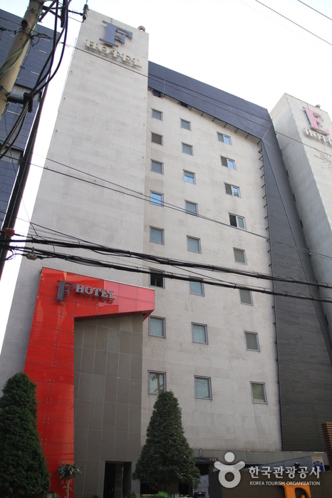 Tall white facade and red entrance canopy of Lifestyle F Hotel