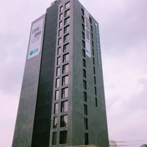 Tall grey exterior of Hotel Bay 204 in Dobong