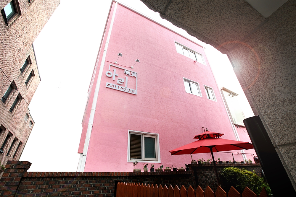 Pink exterior and signed entrance of Ari House Myeongdong