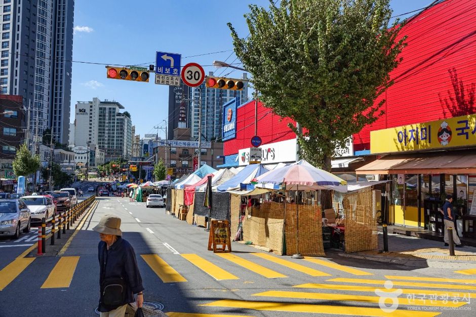 Market canopies and independent storefronts lining the street outside Ilsan Market in Goyang