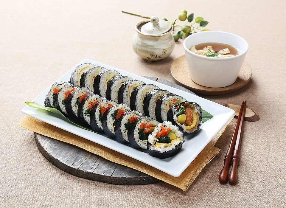 Sliced gimbap rolls showing rice, vegetables, egg and pickled radish fillings