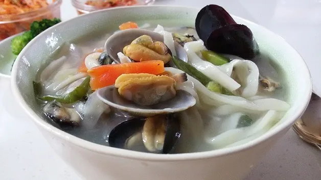 Seafood kalguksu with knife-cut noodles, clams, mussels and vegetables in clear broth