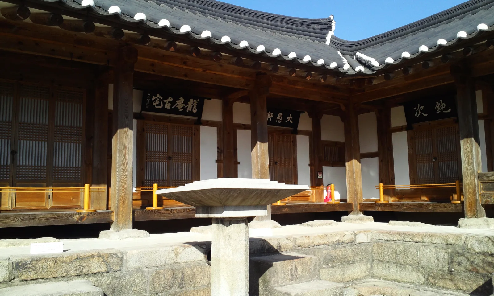 A traditional timber hanok courtyard and stone feature inside Gyochon Hanok Village in Gyeongju