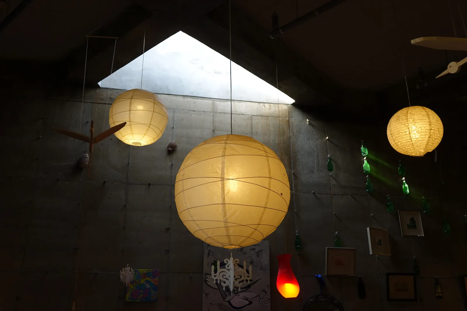 A dark indoor gallery installation of suspended illuminated paper spheres at Haslla Art World