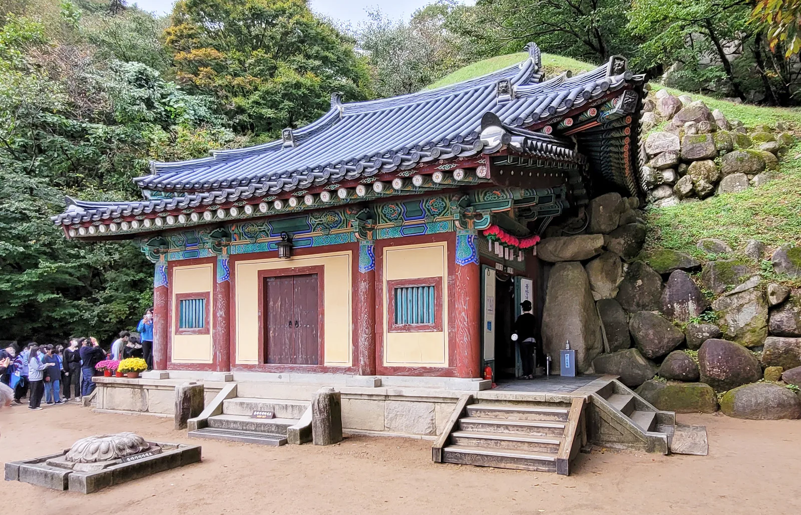 The tiled entrance pavilion of Seokguram Grotto set among forested stone slopes above Gyeongju