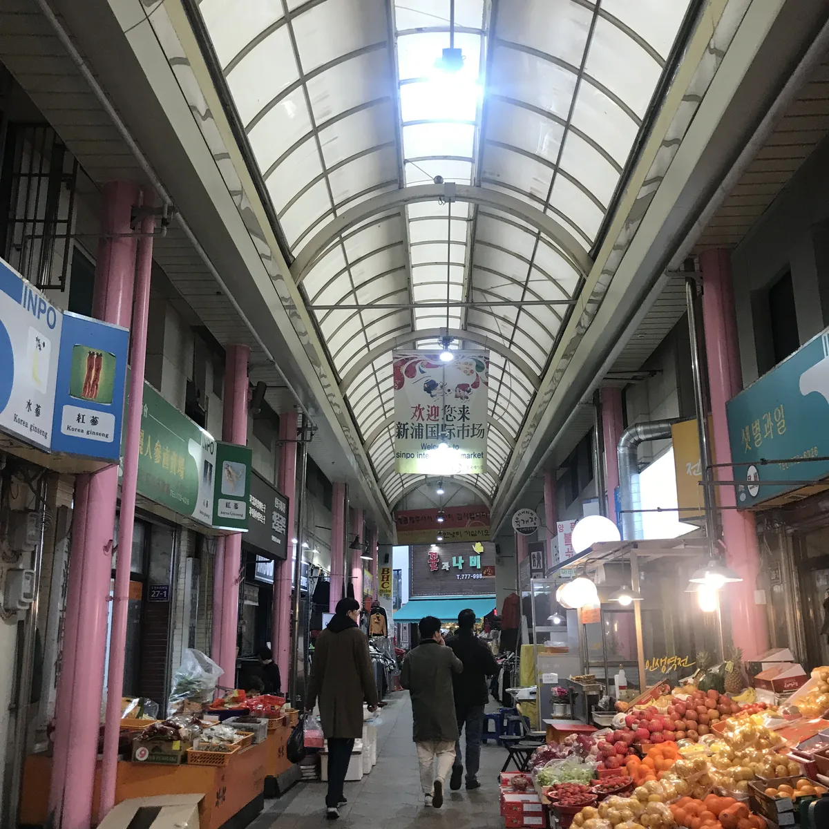 The real covered arcade at Sinpo International Market with produce and prepared-food stalls