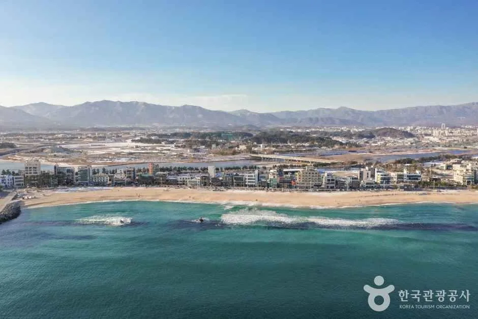 An aerial winter view of Anmok Beach with the full row of seaside cafés along Gangneung Coffee Street
