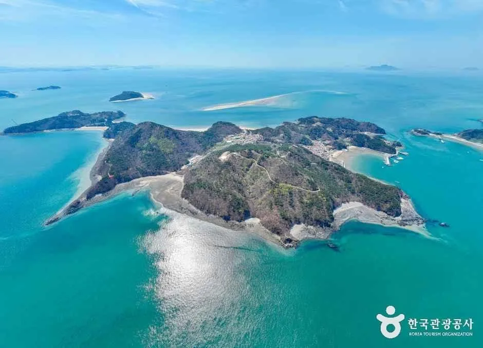 An aerial view of Daeijakdo Island, its wooded ridges and turquoise tidal sandbank in the West Sea