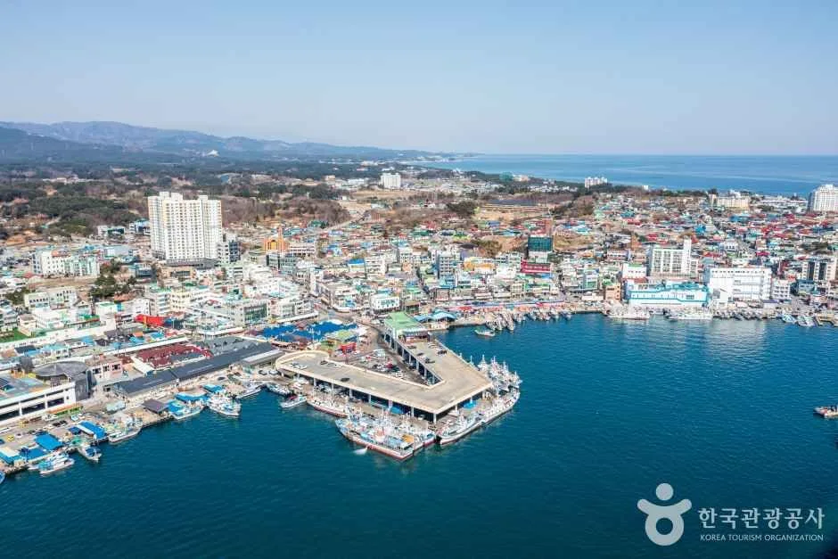 An aerial view of fishing boats, piers, waterfront markets and the town around Jumunjin Port